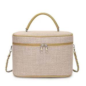 Dettaglio borsa a scatola in tela intrecciata beige con doppia zip e tracolla a catena