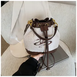 Detail of plush fleece bucket bag showing brown leather base and embroidery