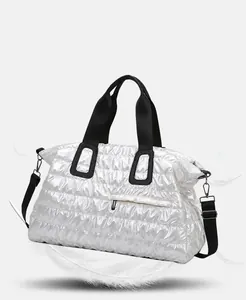Close-up of silver quilted tote bag showing metallic texture and wide black handles