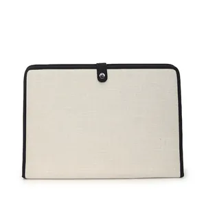 Détail de la pochette d'ordinateur en toile avec bordure noire et bouton pression