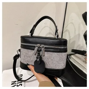 Detail view of mini box handbag with black leather and grey tweed texture contrast