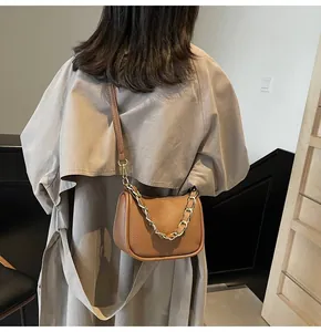 Détail du sac à bandoulière en cuir grainé marron avec sangle réglable et chaîne dorée