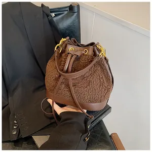 Close-up of coffee brown plush bucket bag with leather drawstring and horse embroidery
