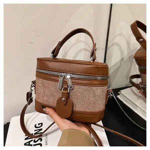 Macro detail of retro leather and canvas bucket bag with dual zippers and strap