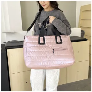 Dettaglio della borsa tote trapuntata rosa con spalline nere e trama satinata liscia