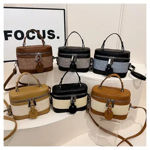 Group shot of mini box bucket bags in six colors displayed on white tiered pedestals