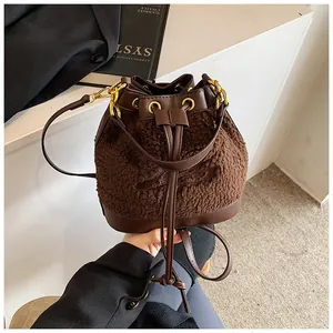 Detail of plush faux shearling and brown leather patchwork on the bucket bag