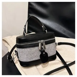 Detail of black leather and grey textured fabric bucket bag with dual zippers and silver hardware
