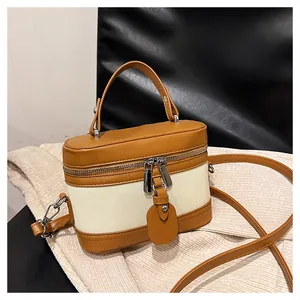 Detail of cream canvas and brown leather stitching on a small retro bucket bag