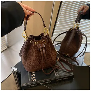 Detail of plush bucket bag featuring brown faux fur texture and gold chain strap
