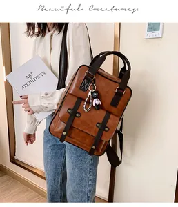 Detail view of vintage PU leather backpack with two-tone design and doll pendant charm