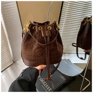 Detail of plush lamb wool bucket bag with leather drawstring and gold metal eyelets