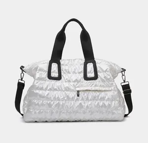 Front view of silver puffer tote bag with quilted fabric and black adjustable shoulder strap