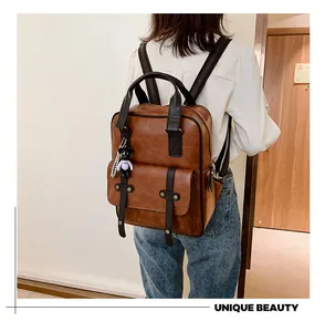 Brown vintage PU leather backpack with black straps and a cute bear keychain charm