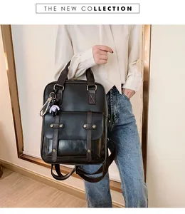 Detail of vintage British style black backpack with brown straps and bear pendant accessory