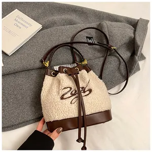 Detailed close-up of plush bucket bag with 2023 embroidery and leather drawstring