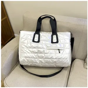 Dettaglio borsa shopper trapuntata bianca con cuciture orizzontali e tracolla nera