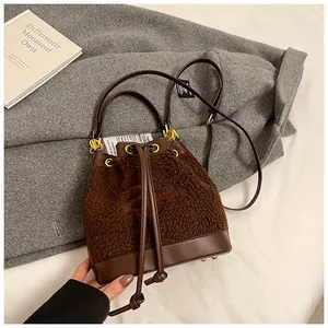 Detail of plush bucket bag with leather drawstring and elegant gold metal hardware