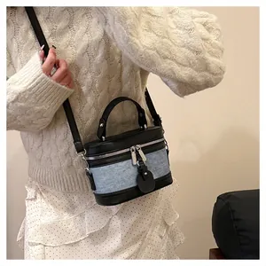 Detail of vanity case bag with black leather and light blue denim patchwork texture