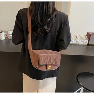 Detail of brown quilted nylon crossbody bag with metal twist lock and adjustable strap