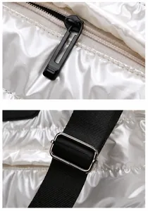 Detail view of durable metal zipper and adjustable strap on white quilted sports bag