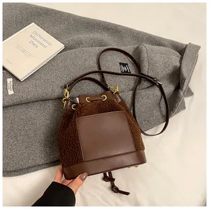 Detail of plush brown teddy bucket bag with leather pocket on wool coat background