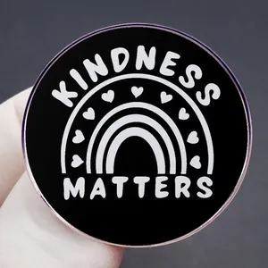 Kindness Matters enamel pin badge with heart rainbow design on black metal background