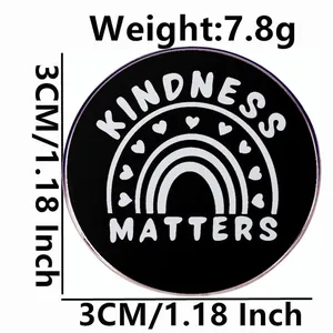 Kindness Matters round metal brooch with rainbow and heart patterns on black background