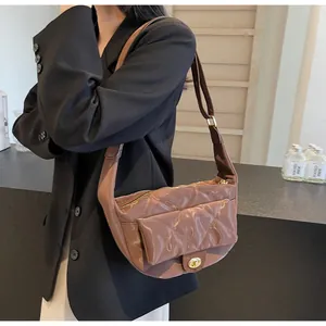Detail of mocha brown quilted shoulder bag with glossy finish and gold twist lock