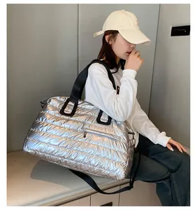 Detailed shot of large silver quilted travel bag with detachable strap and zipper pocket