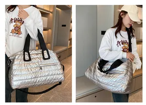 Detail view of metallic silver quilted fitness bag with adjustable shoulder strap for travel