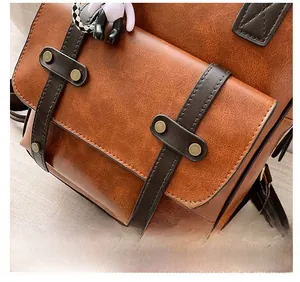 Detailed macro view of vintage brown lychee grain leather backpack with bronze rivets