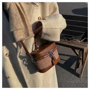 Close-up of brown patchwork bucket bag with leather-textile texture and top handle