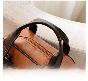 Close-up of vintage brown leather backpack handles with high-quality metal zipper detail