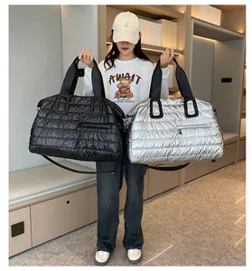 Quilted puffer travel bag in silver and black colors with adjustable shoulder straps
