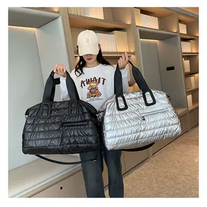 Quilted travel bags in black and silver shown by model for size and capacity reference