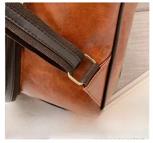 Detailed macro view of vintage brown faux leather backpack with metallic ring and woven strap