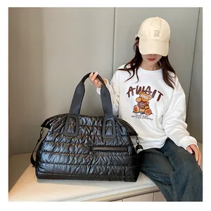 Detail of black quilted puffer gym bag showing shiny nylon texture and side zipper