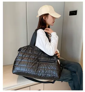 Close-up of a black quilted puffer sports bag with durable nylon handles and side pocket