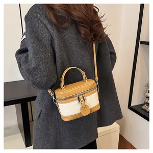 Detail of vintage box-shaped bucket bag in ginger leather and cream canvas with shoulder strap