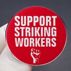 Red Support Striking Workers round pin badge with white fist icon held in hand