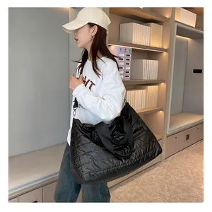 Close-up of a black quilted puffer tote bag featuring soft waterproof fabric and nylon handles