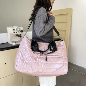 Grande borsa shopper trapuntata rosa con tracolla nera regolabile indossata da una modella