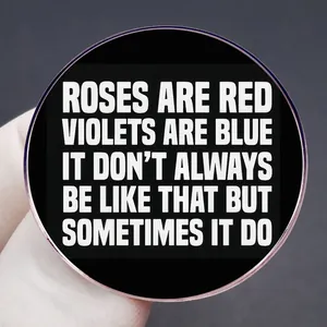 Classic round black metal brooch with white text and elegant rose gold plating detail