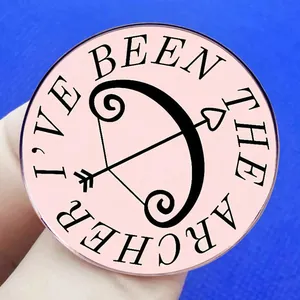Pink round enamel brooch with bow and arrow design featuring I'VE BEEN THE ARCHER text
