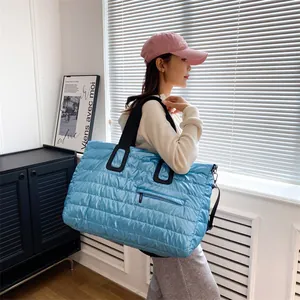Quilted blue puffer gym bag with spacious interior and front zipper pocket for travel