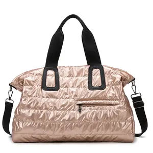 Quilted metallic puffer travel bag in champagne gold with black straps for gym and yoga