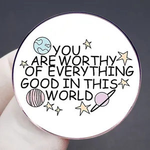 Badge broche rond avec citation 'YOU ARE WORTHY' et motifs d'étoiles sur fond blanc
