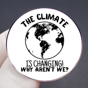Climate change awareness brooch featuring The Climate is Changing slogan on white badge
