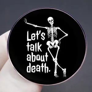 Black enamel pin featuring a skeleton illustration and Let's talk about death text